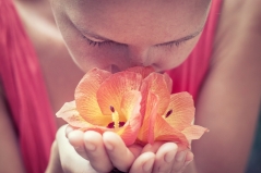 Bild 1: Eine Frau riecht an einer Blume
