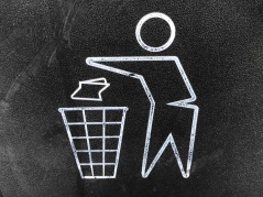 Das Piktogramm eines Papier in den Mülleimer werfenden Menschen