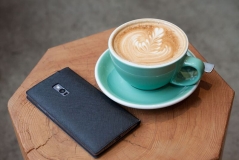 Eine Tasse Kaffee und das Smartphone auf einem Tisch