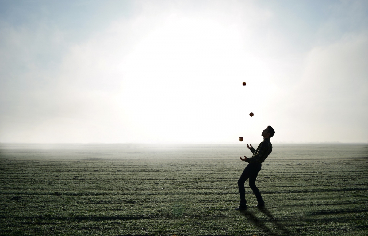 Eine Person jongliert entspannt mit mehreren Bällen. Bild: moise_theodor via pixabay (https://pixabay.com/en/juggler-trick-apple-man-person-1216853/, https://creativecommons.org/publicdomain/zero/1.0/deed.en)