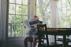Ein älterer Mann liest am Tisch Zeitung